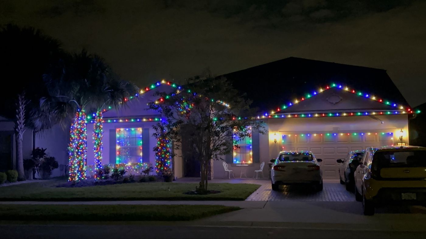 Single-story home with multicolor roofline, window and tree lights